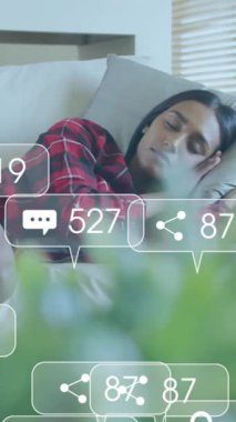 Medya ikonlarının kanepede uyuyan kadın üzerindeki canlandırması. Sosyal medya, yaşam tarzı ve dijital arayüz konsepti dijital olarak oluşturulmuş video.