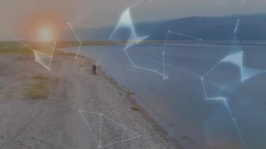 Sahil şeridinde yürüyen adam, hareketli teknoloji ağını harekete geçirir ve el üstünde dönen dünyayı oluşturur. Teknoloji, yenilik, bağlantı, dijital, fütüristik, çevre, ağ