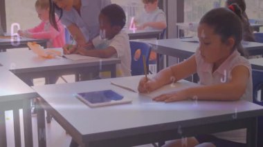 Öğretmen sınıfa giriyor ve diğerleri yazarken çalışma kağıdını göstererek öğrenciye rehberlik ediyor. Eğitim, öğrenim, akıl hocalığı, sınıf, okul, öğrenci bağlılığı, öğretim