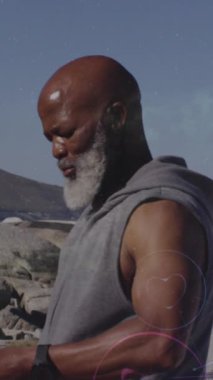 Çevrede kulaklıkları olan Afrikalı Amerikalı kıdemli bir adamın dijital simge ağının animasyonu. Spor ve spor teknolojisi kavramı