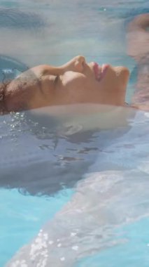 Asyalı bir kadının yüz maskesi taktığı, beyaz bir kadının yüzerken kameraya baktığı animasyon. Coronavirus Covid-19 pandemik konsept dijital bileşik