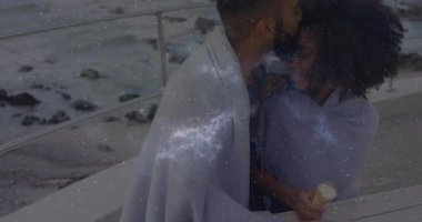 Kozmik örtüler seyahat pazarlaması için çekilirken gri şalda öpüşen çift. Romantizm, samimiyet, dinginlik, gökyüzü, sahil, bağlantı, sükunet