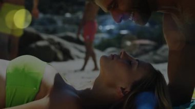 Sahilde güneşlenen bir kadına yaklaşan bir adam mercek fişekleriyle romantizm gösteriyordu. Romantizm, güneşlenme, tatil, yaz, flört, açık hava, manzara