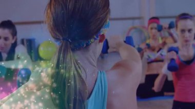 Beden eğitimi hocası, öğrencilere parlayan minderlerin üzerinde ağırlık kaldırma sinyali veriyor. Sağlık, aerobik, motivasyon, çağdaş, dinamik, sağlık, güç