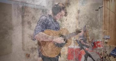 Gitar hazırlayan erkek gitarist, akor çalan kadın davulcu, müzik stüdyosunda ritim tutturuyor. Oturum, işbirliği, melodi, uyum, ses, enstrümantasyon, tür