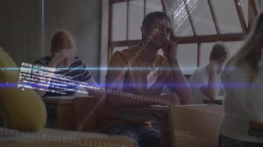 Yazmayı durduran ve ileriye bakan genç çocuk, sınıfların masalarını dolduran teknoloji ikili akımlarını tetikliyor. Eğitim, sınıf, dijital, teknoloji, gençler, öğrenim, yenilik