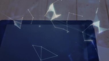 Tabletin üzerinde beliren canlı ağ örgüsü, kahve fincanının yanında ağ bağlantısını gösteren dönen bir küre oluşturuyor. Fütürist, teknoloji, geometrik, yenilik, modern, soyut, çalışma alanı