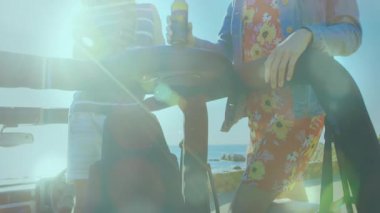 Üstü açılır araba sahil manzarasında duruyor, bir çift tırabzanlara yaslanıyor seyahat reklamı için kadeh kaldırıyor. Manzara, romantizm, eğlence, açık hava, macera, yaşam tarzı, canlı