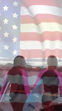 Amerika bayrağının yaz aylarında sahilde sörf tahtası olan mutlu kadınlar üzerinde canlandırılması. Amerikan vatanseverliği, çeşitlilik ve tatil konsepti dijital olarak oluşturulmuş video.