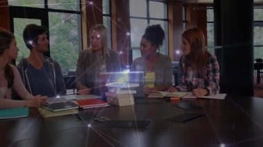 Sarışın kadın öne eğilip çalışma masasında çalışma grubuyla konuşuyor ve görevleri not alıyor. İşbirliği, takım çalışması, eğitim, öğrenme, grup tartışması, beyin fırtınası, profesyonel