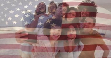 Sosyal medya selfie 'si için plaja gelen arkadaşlar bayrak sallayarak fotoğraf çekiyorlar. Sıradan, yoldaşlık, kutlama, eğlence, canlı, açık hava, mutluluk.