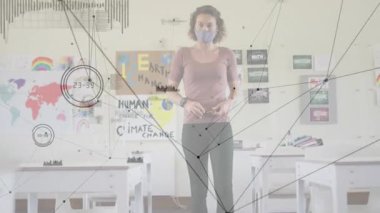 Bayan öğretmen saate bakıyor ve iklim malzemelerini derste çekilirken topluyor. Eğitim, sınıf, dijital, teknoloji, öğrenme, çevre, ilham