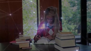 Masadaki araştırma danışmanı fikir özetlerken animasyon ağ örtüşmesi başlatan ders kitaplarına bakıyor. Çalışkan, kütüphane, dijital, yenilik, öğrenme, odaklanma, dalgınlık