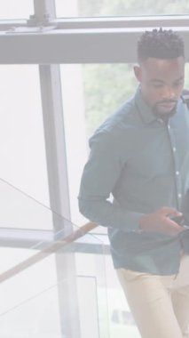 Afro-Amerikan iş adamının şehir manzarası üzerinde akıllı telefon kullanması. Küresel iş, finans, dijital arayüz, hesaplama ve veri işleme kavramı dijital olarak oluşturulmuş video.