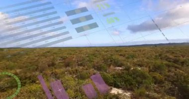 İHA kameraları ovalanan alanda gezinirken tablo soluklaşıyor ve kayan görselleştirme veri eğilimlerini örtüyor. Peyzaj, analitik, veri görselleştirme, modern, teknoloji, hava, çevre