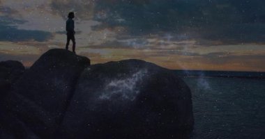 Güneş batarken kayalara tırmanan bir kadın teknolojinin örtüşmesine ve telefona cevap vermesine neden oluyor. Kıyı şeridi, yalnızlık, macera, alacakaranlık, gökyüzü, keşif, vahşi doğa.