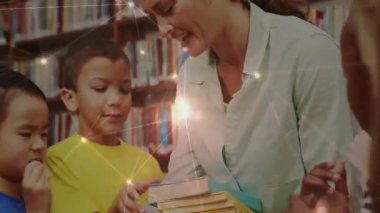 Öğretmen öğrencilere renkli bir kitap sunarak okul kütüphanesinde kitap dağıtımını başlatıyor. Eğitmen, okur yazarlık, öğrenme, sınıf, bilgi, eğitim, okuma