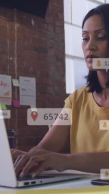 Ofiste dizüstü bilgisayar kullanarak kadınlara karşı yüzen sosyal medya simgelerinin animasyonu. Sosyal medya ağı ve iş teknolojisi kavramı