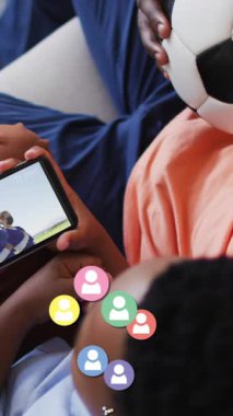 Afrika kökenli Amerikalı baba ve oğlunun akıllı telefondan futbol izlemesi üzerine sosyal medya ikonlarının canlandırılması. küresel sosyal medya, dijital arayüz ve dijital olarak oluşturulan öğrenme konsepti.