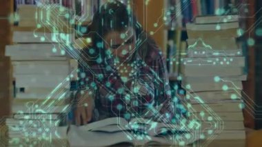 Kadın kütüphanede kitap açıyor ve araştırma sırasında yeşil devrelerin nabzını kestiği sayfaları tarıyor. Entelektüel, odaklanma, bilgi, yenilik, çalışma, merak, konsantrasyon