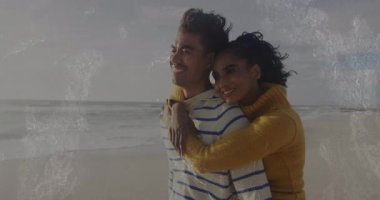 Bir kadın kumlu sahilde erkeğe yaklaşıyor ve aşk macerasını kutlamak için sarılıyor. Romantizm, şefkat, bağlantı, dinginlik, sahil, şefkat, yaşam tarzı