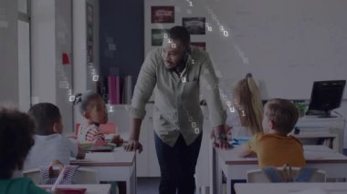 Öğretmen sıralara yaslanıyor ve sınıfın kodlama oturumunda ikili yağmuru başlatıyor. Eğitim, teknoloji, dijital, yenilik, öğrenme, sınıf, işbirliği