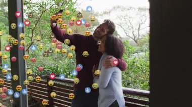 Sosyal medya tepkimeleri ikonlarında foto çekmek için ahşap güvertede akıllı telefon kaldıran çift. Romantizm, bağlantı, açık hava, eğlence, teknoloji, bağlılık, doğal