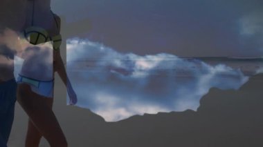 Sahil şeridi boyunca yürüyen sörf tahtası taşıyan bir çift seyahat yansıması sırasında karşıya geçiyorlar. Deniz kenarı, gün batımı, maneviyat, bağlılık, meditasyon, dinginlik, macera