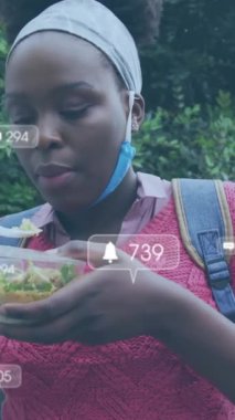 Afro-Amerikan bir kadının öğle yemeği yemesi üzerine medya simgelerinin canlandırılması. Gıda, sosyal medya ve dijital arayüz konsepti dijital olarak oluşturulmuş video.