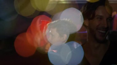 Animasyon Bokeh 'ten geri çekilen kamera pazarlama etkinliğinde kırmızı bardak kaldıran adam. Kutlama, dostluk, gece hayatı, sosyal toplanma, canlı, neşeli, samimi