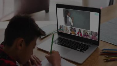 Çocuk dizüstü bilgisayarı açıp çevrimiçi kodlama dersine katılarak notları kopyalıyor ve kodları üst üste koyuyor. Teknoloji, eğitim, uzaktan öğrenme, dijital arayüz, konsantrasyon, yenilik, gençlik