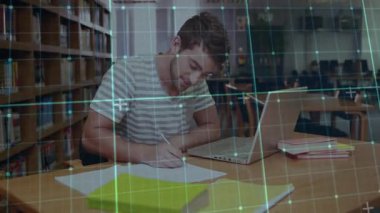 Öğrenci gümüş dizüstü bilgisayara bakıyor ve eğitim araştırmaları için şebeke kaplamalı notlar yazıyor. Öğrenme, odaklanma, konsantrasyon, öğrenim, akademi, kütüphane, eğitim