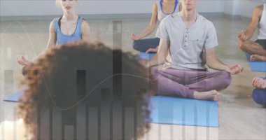 Eğitmen nefes alıyor ve öğrencilere yoga stüdyosunda harita kaplamalarıyla kollarını kaldırmaları için rehberlik ediyor. Farkındalık, dinginlik, denge, meditasyon, sağlık, uyum, esneklik