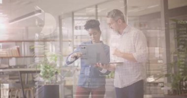 Kadın tableti tıklatıyor ve veri incelemesi için dijital grafikleri açıklarken meslektaşı öngörüleri işaret ediyor. İşbirliği, veri analizi, teknoloji, iş dünyası, takım çalışması, modern, profesyonel