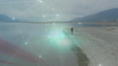 Adamın biri görüş alanına giriyor ve göl kıyısında nabız teknolojisiyle düğümler ve çizgilerle yürüyor. Yalnız, kıyı şeridi, teknoloji, soyutlama, yalnızlık, doğa, fütüristik