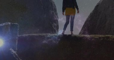 Kaşif, kayalık tepeye ayak basıyor ve astronomiyi etkinleştiriyor. Macera, yalnızlık, keşif, kozmik, gece manzarası, engebeli, düşünceli.