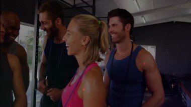 Spor grubu çömelme sahasına katılıyor, atlama iplerini tutuyor ve antrenmanı kutluyor. Sporcular, takım çalışması, kararlılık, yoldaşlık, enerji, motivasyon, modern