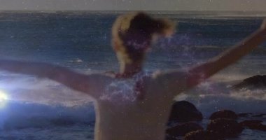 Kadın kollarını indirirken, kozmik kaplamayı aktifleştiren mercekler teknolojik okyanus füzyonu için saçlarını gevşetiyor. Gökyüzü, deniz manzarası, mistik, dinginlik, atmosfer, enerji, meditasyon