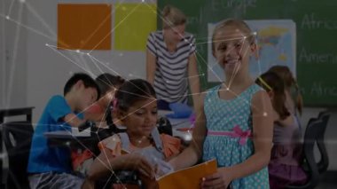 Turuncu kitap okuyan bir kız sayfa çeviren bir akranla, harita ile coğrafya öğreten bir öğretmen. Özel eğitim, erişilebilirlik, takım çalışması, çeşitlilik, sınıf ortamı, öğrenme, katılım