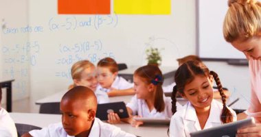 Öğretmenin sınıfa girmesi saç örgülü öğrenciyi matematik diyagramlarıyla tablete yerleştirmesi. Sınıf, eğitim, öğrenme, teknoloji, akıl hocalığı, işbirliği, gençlik