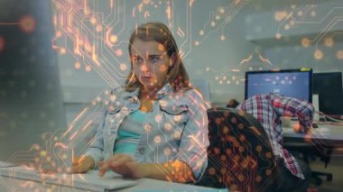 Klavyede yazan ve teknik ofiste devre kartı grafikleri çalıştıran bir kadın odak noktasını gösteriyor. Teknoloji, yenilik, dijital, işbirliği, çalışma alanı, konsantrasyon, modernite