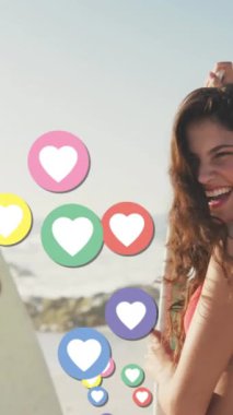 Sahilde sörf tahtası olan arkadaşlara karşı kalp dijital simgelerinin animasyonu. dijital arayüz, sosyal medya ve küresel teknoloji konsepti dijital olarak oluşturulmuş video.