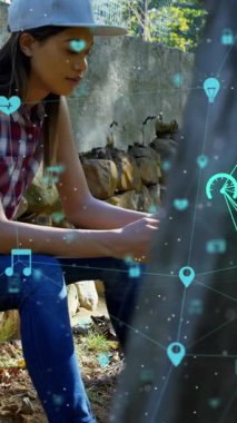 Açık havada akıllı telefon kullanarak kadınlara karşı dönen dijital simgeler küresi. küresel ağ ve teknoloji kavramı