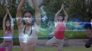 Yoga grubu ağacı dengeliyor ve titreyen ışığın yoğun meditasyonu gibi elleri duaya indiriyor. Ruhani, sağlıklı, farkındalık, uyum, doğa, dinginlik, hizalama