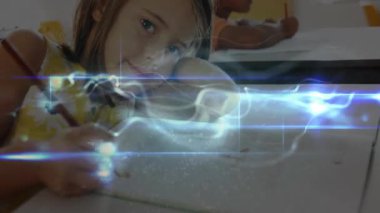 Sınıfta yazan kız öğrenci çalışma odasının etrafında dijital ışık girdabına neden oluyor. Eğitim, çocukluk, öğrenme, yaratıcılık, teknoloji, odaklanma, takım çalışması