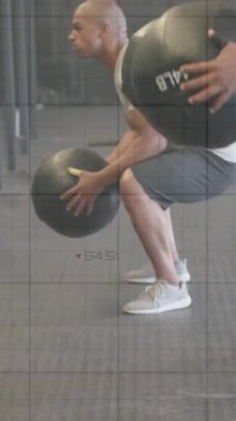 Çeşitli erkek gruplarının spor salonundaki tıp toplarıyla çapraz eğitimlerinin grafik işleme verilerinin animasyonu. Fitness, egzersiz, güç, veri, dijital arayüz ve dijital olarak üretilen video.