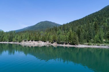 Açık mavi gökyüzüne karşı dağdan nehre ormanın manzarası