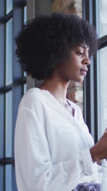 Animation of social media icons over african american businesswoman. Global social media, business, finances, computing and data processing concept digitally generated video.