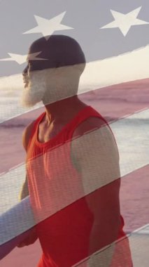 Sahilde yoga minderli yaşlı Afro-Amerikan bir adam için Amerikan bayrağının animasyonu. Amerikan vatanseverliği, milliyeti, yaz ve çeşitlilik konsepti dijital olarak oluşturulmuş video.