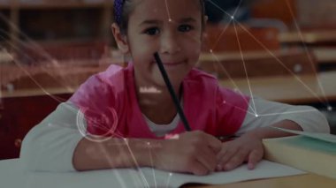 Öğrenci kalem kaldırıyor, sonra kağıda döküyor, eğitim için ağ örtüleri arasında yazmaya başlıyor. Öğrenim, eğitim, sınıf, öğrenim, çocukluk, konsantrasyon, yaratıcılık